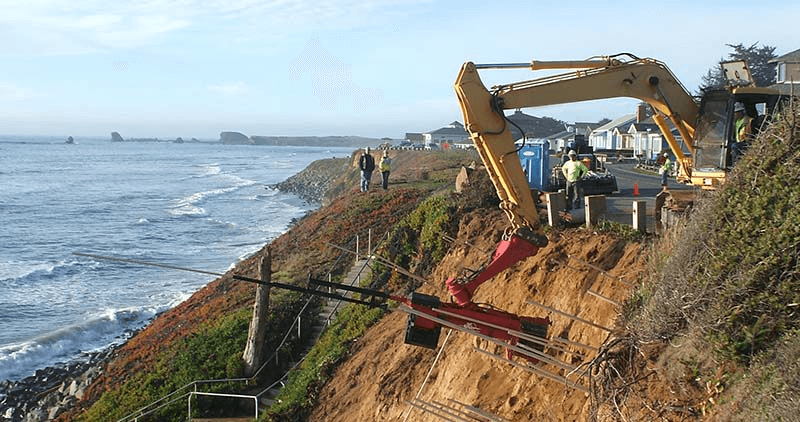 construction equipment working on side of cliff
