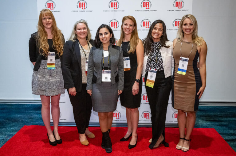five women in front of dfi branded backdrop