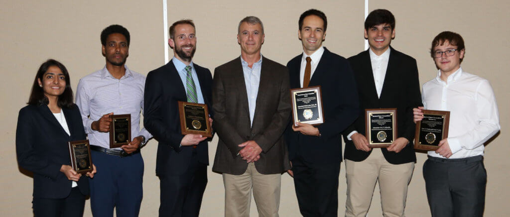 award recipients posing with plaques