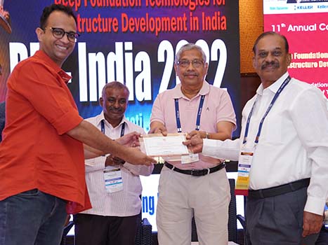 4 people at a conference holding a plaque