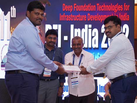 4 people at a conference holding a plaque