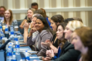 banquet table crowded with people and microphones