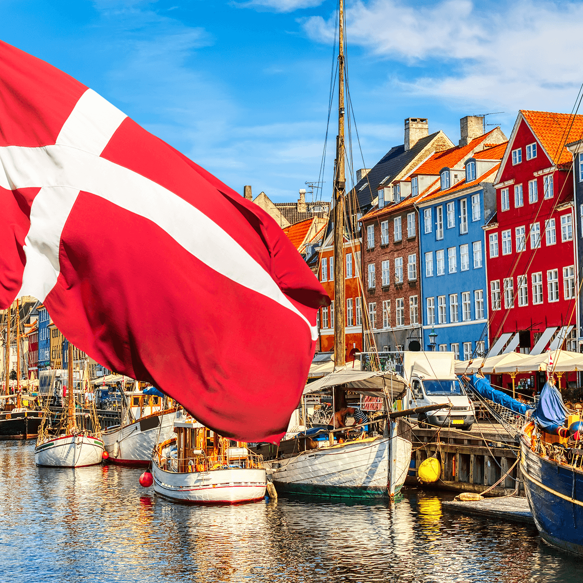 flag in front of row of boats with waterfront buildings