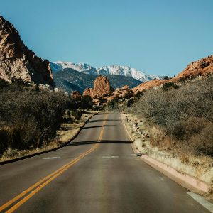 An empty road cutting through mountains.
